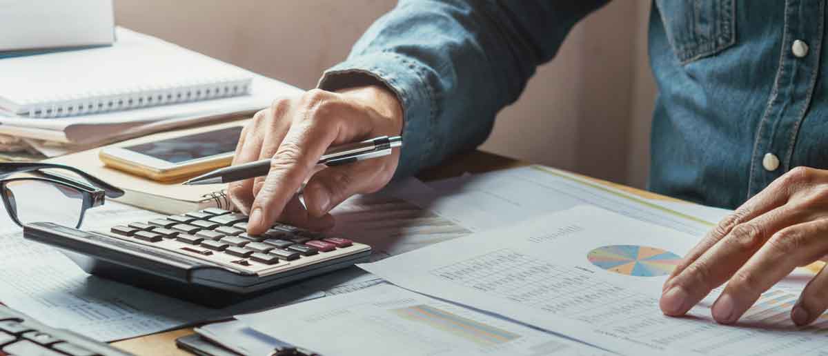 Person using a calculator to determine budget