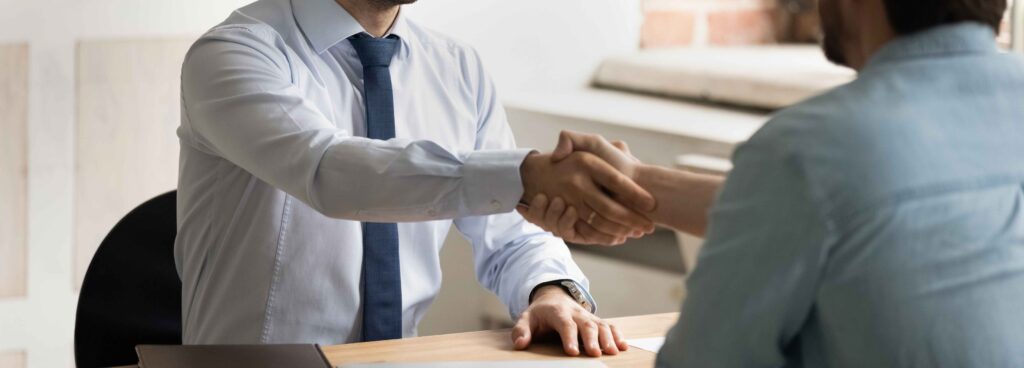 2 people shaking hands in an interview
