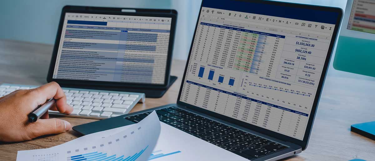 spreadsheets on multiple computer screens