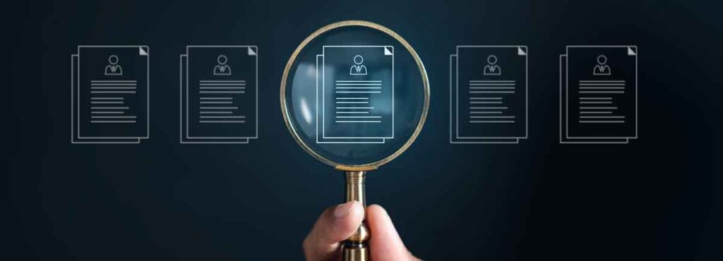 magnifying glass focusing on one resume